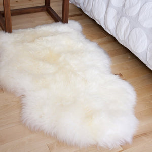 Peau de mouton véritable à poil long au pied du lit